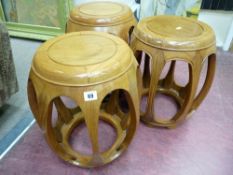 THREE CHINESE ROSEWOOD BARREL SHAPED STOOLS having circular tops with open panel sides, 45 cms