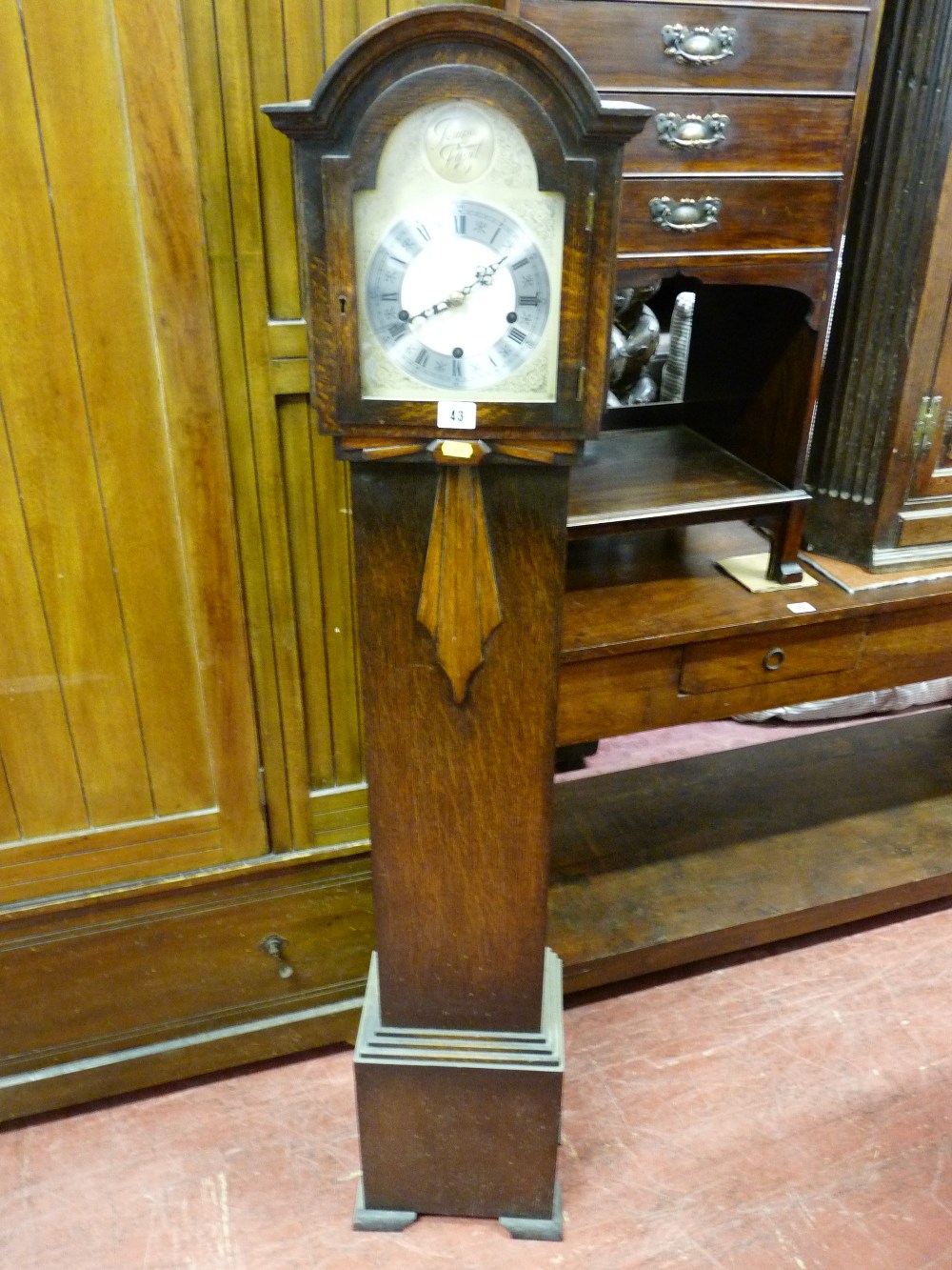 A 1930'S POLISHED ENCASED DOME TOPPED GRANDMOTHER CLOCK having a silvered dial and eight day