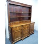 AN EARLY 19th CENTURY NORTH WALES OAK & CROSSBANDED MAHOGANY BREAKFRONT DRESSER, the three shelf