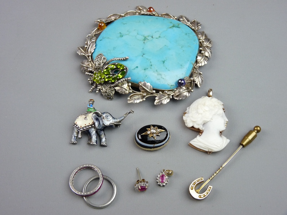 A LARGE SHAPED BLUE STONE PENDANT in a white metal, possibly silver frame, the frame adorned with