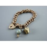 A NINE CARAT GOLD HOLLOW LINK BRACELET & PADLOCK with safety chain and two charms (a bucket and a