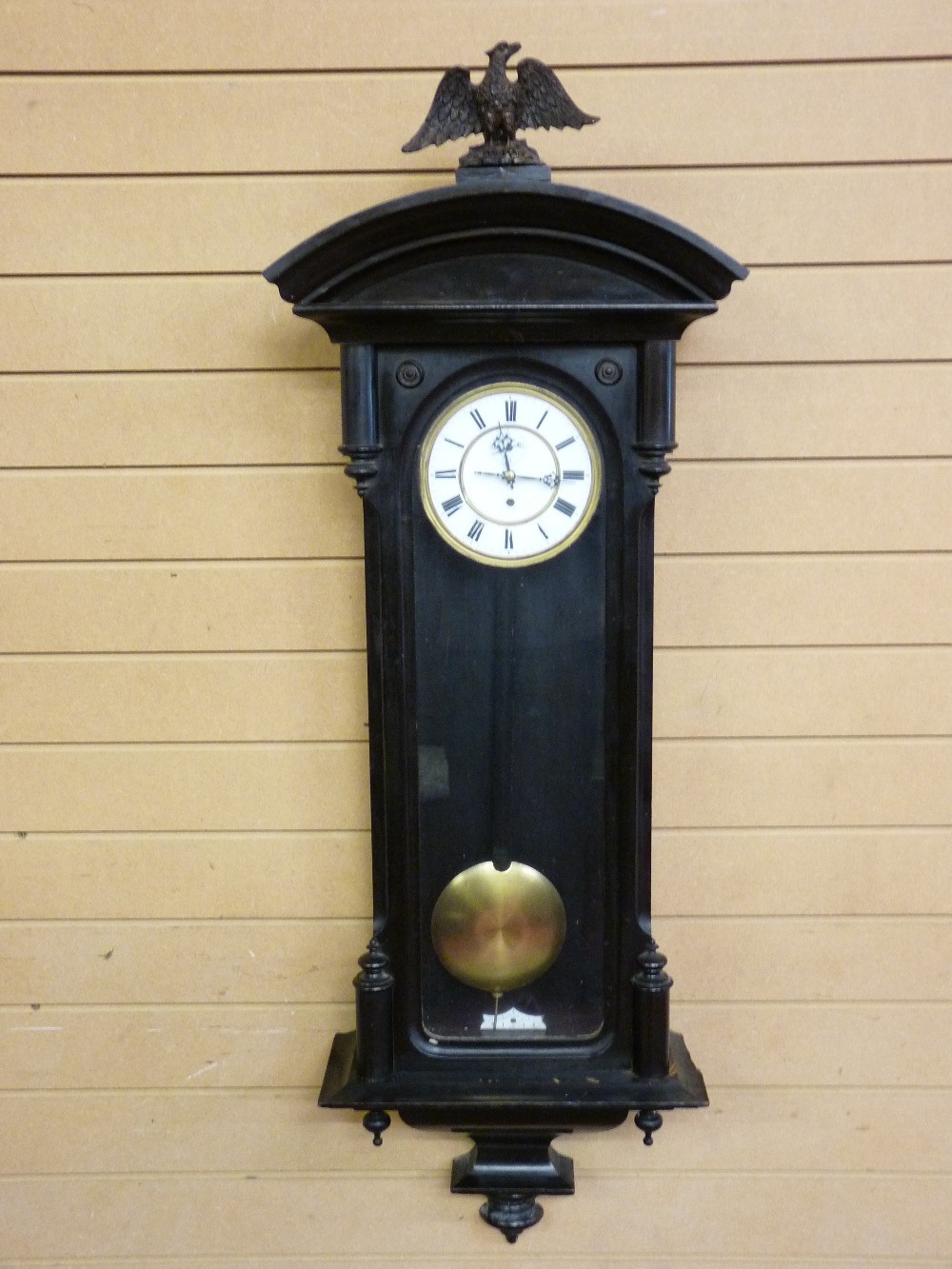 A VIENNA STYLE WALL CLOCK in an ebonized case, the single weight pendulum driven movement with white