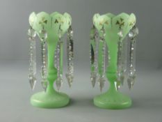 A PAIR OF VICTORIAN GREEN SATIN GLASS LUSTRES having gilt leaf decoration and facet cut drops, 27.