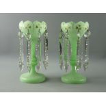 A PAIR OF VICTORIAN GREEN SATIN GLASS LUSTRES having gilt leaf decoration and facet cut drops, 27.