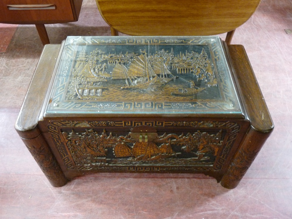A CARVED ORIENTAL CAMPHORWOOD CHEST, deep carved with harbour scenes and Chinese junks and having