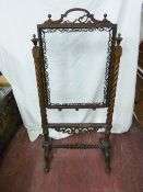 A VICTORIAN ROSEWOOD FIRESCREEN, the clear glass central panel with fretwork edge decoration and