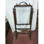 A VICTORIAN ROSEWOOD FIRESCREEN, the clear glass central panel with fretwork edge decoration and