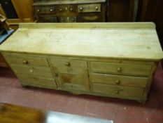 A GOOD ANTIQUE PINE DRESSER BASE, the railback two boarded top with rounded front corners, the lower