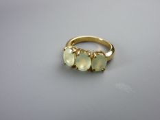 A NINE CARAT GOLD DRESS RING with three oval peridots, size 'N', 4 grms