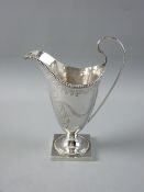 A SQUARE BASED HELMET SHAPED SILVER CREAM JUG with bright cut and beadwork decoration, 4 troy ozs,