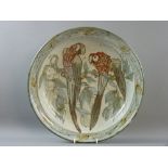 AN ENGLISH STUDIO POTTERY DISHED CIRCULAR CHARGER depicting two perched parrots, 42 cms diameter