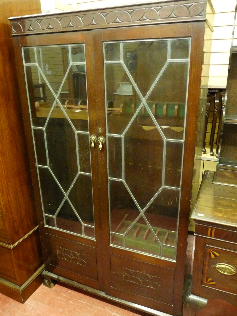 AN EARLY 20th CENTURY MAHOGANY GUN CABINET, the twin glazed doors with strip lead decoration and