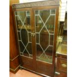 AN EARLY 20th CENTURY MAHOGANY GUN CABINET, the twin glazed doors with strip lead decoration and