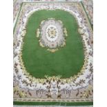 A GREEN GROUND INDIAN HAND KNOTTED WOOLLEN CARPET with cream and mushroom coloured border and