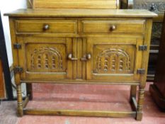 A SMALL REPRODUCTION OAK SIDEBOARD of two drawers and two cupboard doors with arched carved