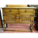 A SMALL REPRODUCTION OAK SIDEBOARD of two drawers and two cupboard doors with arched carved