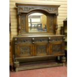 A CARVED OAK MIRRORBACK SIDEBOARD, the top section with arched top bevelled edge mirror, flanking