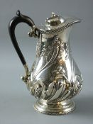 A SILVER HOT WATER JUG/COFFEE POT with fine swirled leaf decoration to a short circular pedestal