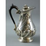 A SILVER HOT WATER JUG/COFFEE POT with fine swirled leaf decoration to a short circular pedestal