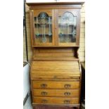AN ARTS & CRAFTS STYLE OAK BUREAU BOOKCASE, the top with inverted crown over twin glazed doors