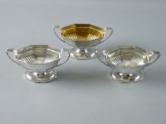 A TRIO OF OCTAGONAL BASED SILVER SALT CELLARS, boat shaped with twin handles and reeded