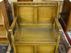 A NEAT OAK MONK'S BENCH with turned arm supports and box seat base, 72 cms high, 81.5 cms wide, 48.5