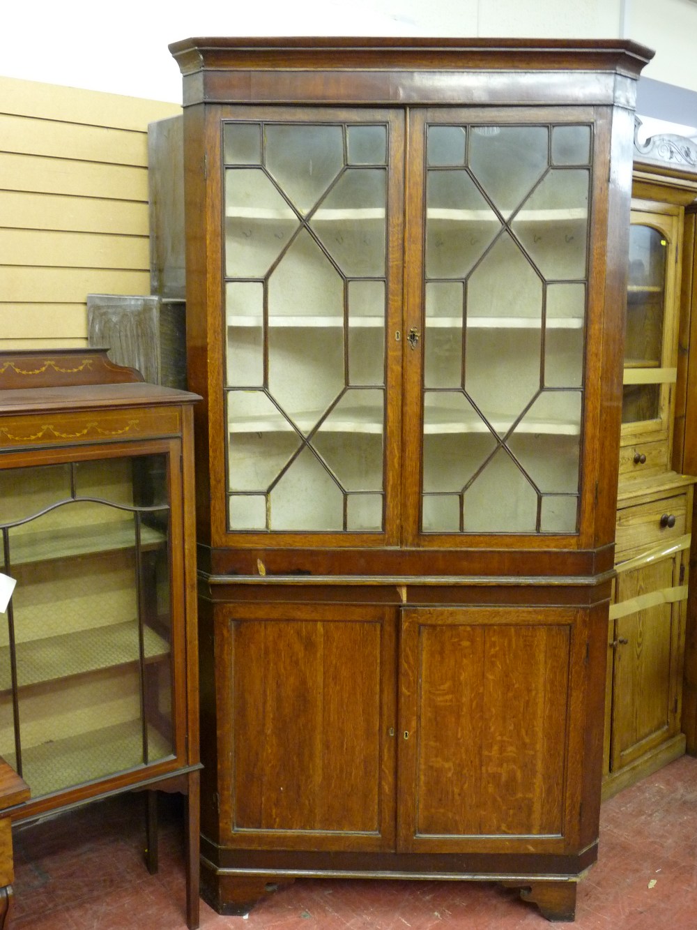 A GEORGIAN OAK & MAHOGANY TWO PIECE CORNER CUPBOARD, the top section with twin thirteen pane