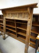 A LARGE CARVED OAK FIRE SURROUND with deep mantel shelf, the front having carved floral panels and