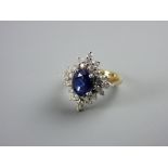 AN EIGHTEEN CARAT GOLD TANZANITE & DIAMOND DRESS RING having a centre oval blue stone with