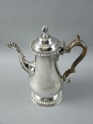 A CIRCULAR BASED GEORGIAN SILVER COFFEEPOT of plain form with a domed and knopped hinged lid and