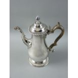 A CIRCULAR BASED GEORGIAN SILVER COFFEEPOT of plain form with a domed and knopped hinged lid and