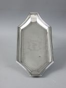 AN OBLONG SILVER PEN TRAY of shaped form with decorative banding and crest to the base, 4 troy