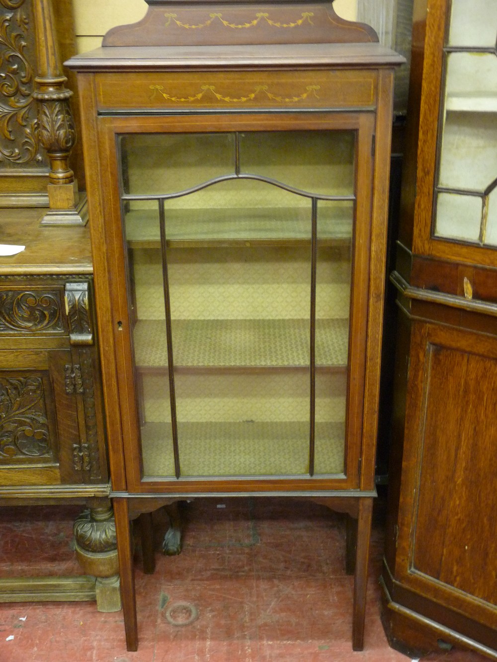 AN EDWARDIAN INLAID MAHOGANY CHINA DISPLAY CABINET, the shaped railback with ribbon swag decoration,