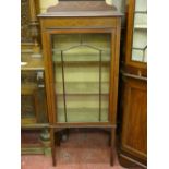 AN EDWARDIAN INLAID MAHOGANY CHINA DISPLAY CABINET, the shaped railback with ribbon swag decoration,