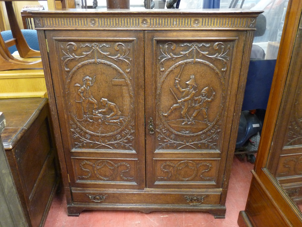 A 20th CENTURY CARVED CUPBOARD with single base drawer having reeded frieze decoration and sides,