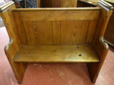 A PITCH PINE CHURCH PEW neatly proportioned with sloping rear book rail and shaped front arms, 105