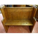 A PITCH PINE CHURCH PEW neatly proportioned with sloping rear book rail and shaped front arms, 105