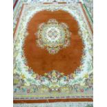 A 20th CENTURY INDIAN HAND KNOTTED CARPET with rust ground centre and border, brightly coloured