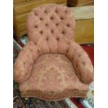 A VICTORIAN WALNUT FRAMED SALON ARMCHAIR, button upholstery with shaped seat front on turned front