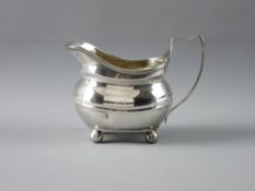 AN OVAL PLAIN SILVER CREAM JUG on four ball supports, 4 troy ozs, London 1812 (one impact dent to