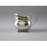 AN OVAL PLAIN SILVER CREAM JUG on four ball supports, 4 troy ozs, London 1812 (one impact dent to