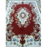 A 20th CENTURY HAND KNOTTED WOOLLEN CARPET probably Indian, with scattered floral pattern on a cream