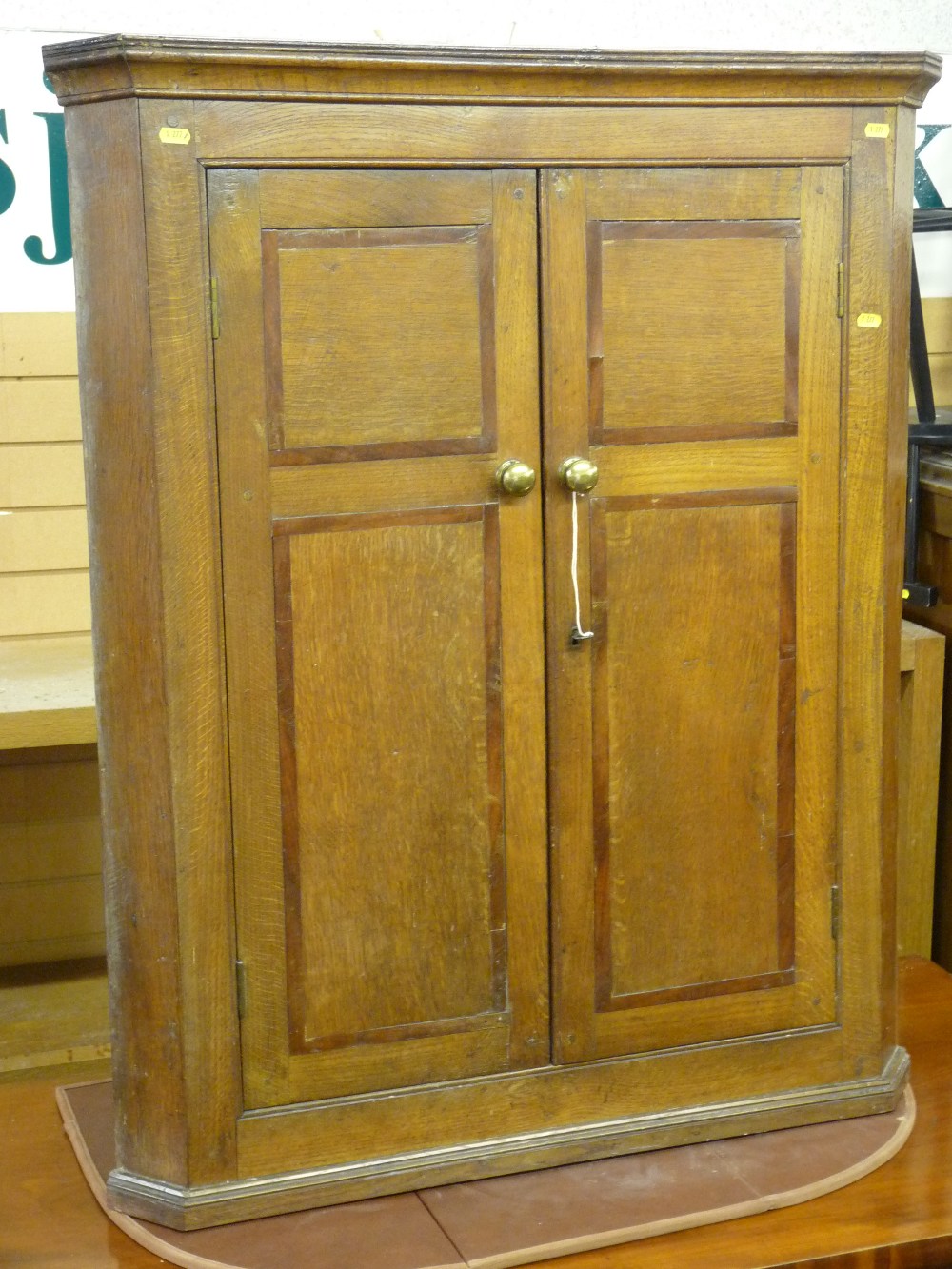 AN OAK AND CROSSBANDED MAHOGANY TWO DOOR HANGING CORNER CUPBOARD, early 19th Century flat fronted,