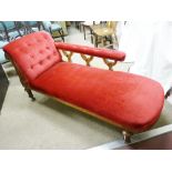 A LATE VICTORIAN WALNUT CHAISE LONGUE having a red dralon buttoned end with long arm rest and with