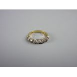 AN EIGHTEEN CARAT GOLD SEVEN STONE DIAMOND RING, size 'K', 2.7 grms