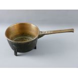 AN ANTIQUE BRONZE THREE FOOTED SKILLET PAN, 22 cms diameter, the handle marked 'W H 4'
