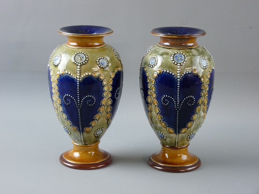 A PAIR OF ROYAL DOULTON STONEWARE VASES of baluster form with flared rim and foot having raised