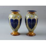 A PAIR OF ROYAL DOULTON STONEWARE VASES of baluster form with flared rim and foot having raised