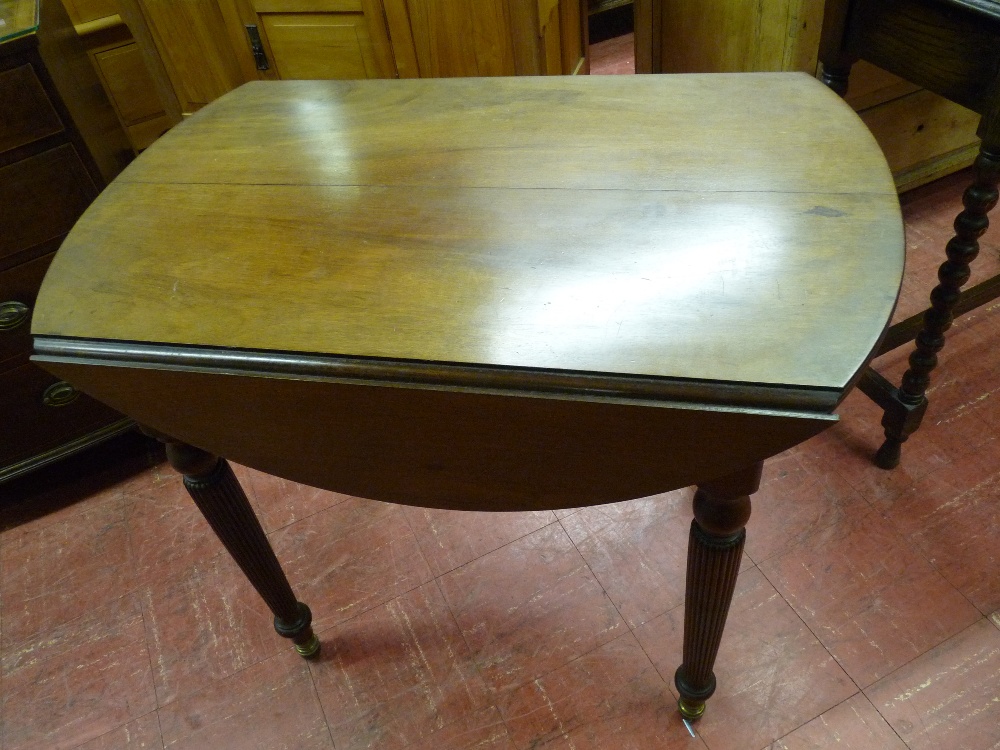 A REGENCY STYLE MAHOGANY TWIN FLAP EXTENDING TABLE, the top with reeded edge and turned reeded