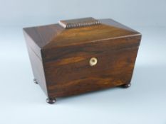 A VICTORIAN ROSEWOOD TEA CADDY of sarcophagus form on turned bun feet, the interior with twin lidded